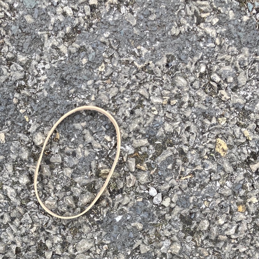 'Seven and a Half Heads to One Body'. A discarded elastic band makes the shape of a head on an artist's wooden body model.