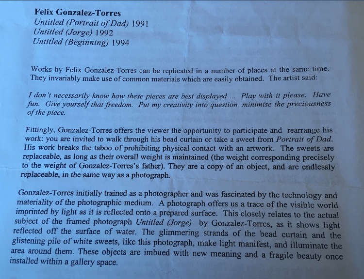 A paper with text on it
Description automatically generated.

Works by Felix Gonzalez-Torres can be replicated in a number of places at the same time. They invariably make use of common material which are easily obtained. The artist said:

I don’t necessarily know how these pieces are best displayed ... Play with it please. Have fun. Give yourself that freedom. Put my creativity into question, minimise the preciousness of the piece.

Fittingly, Gonzalez-Torres offers the viewer the opportunity to participate and rearrange his work: you are invited to walk through his bead curtain or take a sweet from Portrait of Dad. His work breaks the taboo of prohibiting physical contact with an artwork. The sweets are replaceable, as long as their overall weight is maintained (the weight corresponding precisely to the weight of Gonzalez-Torres father). They are a copy of an object, and are endlessly replaceable, in the same was as a photograph.

Gonzalez-Torres initially trained as a photographer and was fascinated by the technology and materiality of the photographic medium. A photograph offers us a trace of the visible world imprinted by light as it is reflected onto a prepared surface. This closely relates to the actual subject of the framed photograph Untitled (Jorge) by Gonzalez-Torres, as it shows light reflected off the surface of water. The glimmering strands of the bead curtain and the glistening pile of white sweets, like this photograph, make light manifest, and illuminate the area around them. These objects are imbued with new meaning and a fragile beauty once installed within a gallery space.
Actual text.
